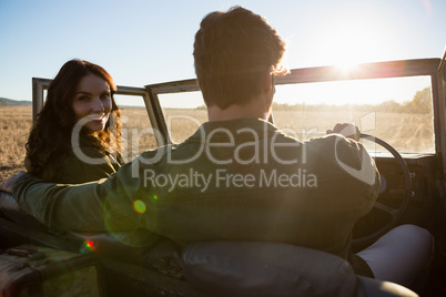 Woman with man in off road vehicle on landscape
