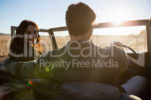 Woman with man in off road vehicle on landscape