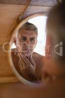 Man looking at mirror in cottage