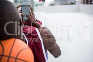 Basketball player using mobile phone