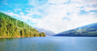 River amidst mountains during sunny day