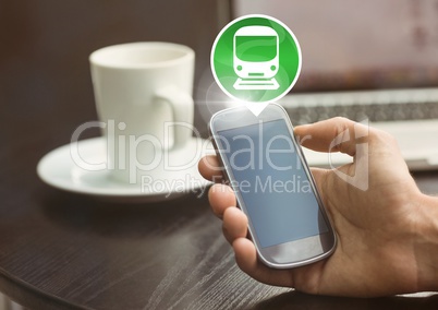 Hand holding phone with train icon at table