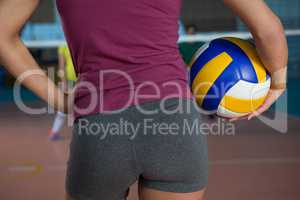 Mid section of volleyball player holding ball