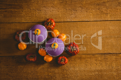 Overhead view of cup cakes with small pumpkins