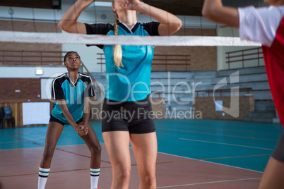 Female players playing volleyball in the court