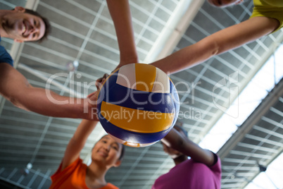 Coach and female players holding volleyball