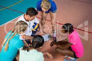 Volleyball coach talking to female players