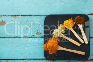 Various spice powder in wooden spoon