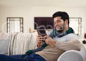 Man in Autumn with tablet and scarf on couch at home