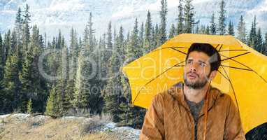 Man with yellow umbrella in forest