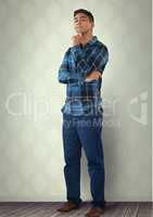 Intelligent man standing thinking against wall in room