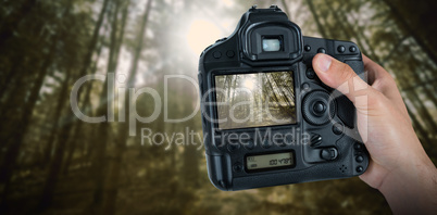 Composite image of cropped hand of photographer holding camera