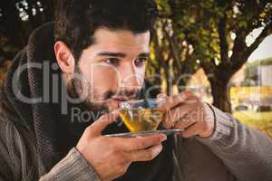 Composite image of thoughtful man having lemon tea