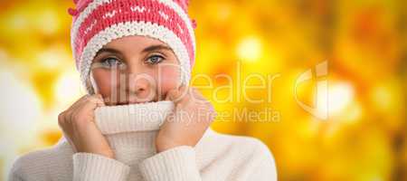 Composite image of portrait of woman covering face with turtleneck sweater