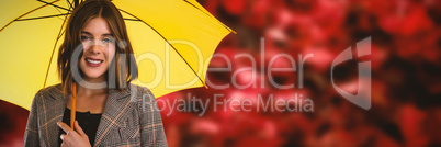 Composite image of portrait of smiling woman with yellow umbrella