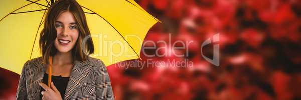 Composite image of portrait of smiling woman with yellow umbrella