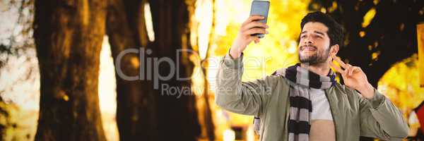 Composite image of smiling man taking selfie through mobile phone