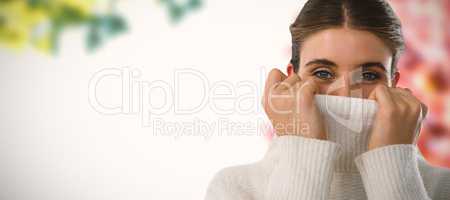 Composite image of portrait of young woman covering face with turtleneck sweater