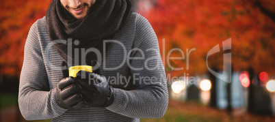 Composite image of young man holing mug of coffee