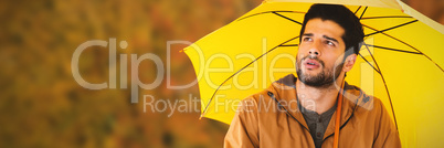 Composite image of thoughtful man with yellow umbrella