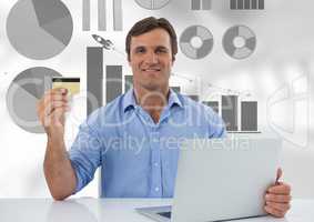 Businessman at desk with laptop  and bank card and  pie chart bar chart statistics