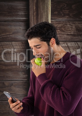 Man against wood with apple and phone