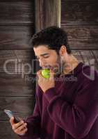 Man against wood with apple and phone