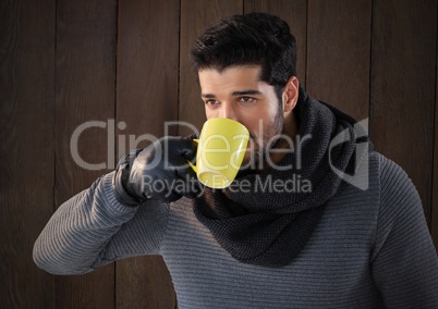 Man against wood with warm scarf and gloves and cup