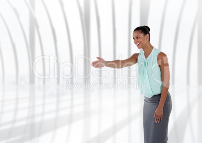 Businesswoman  reaching out for handshake by windows