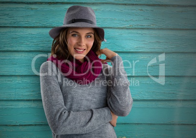 Woman against wood with warm scarf and hat