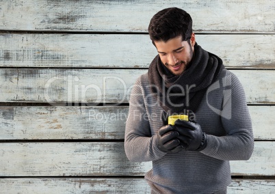 Man against wood with warm scarf and gloves and jumper