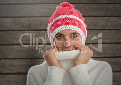 Woman against wood with warm woollen hat and jumper