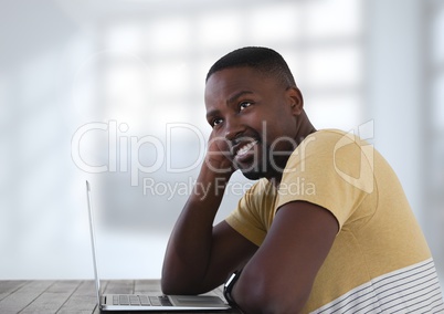Businessman at desk with laptop with bright background