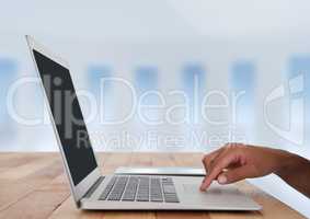 Business hand at desk with laptop with bright background