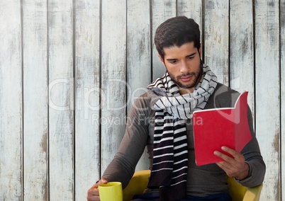 Man against wood with book and scarf and cup