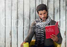 Man against wood with book and scarf and cup