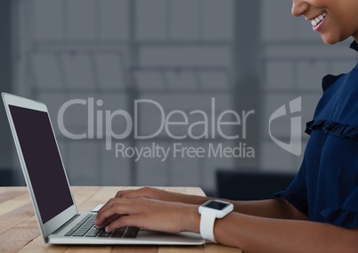 Businesswoman at desk with laptop with dark background