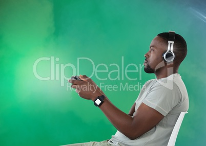 man playing with computer game controller with green fog background