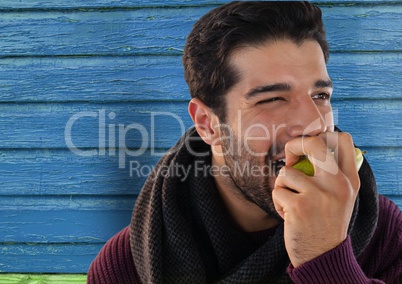 Man against wood with pear and scarf