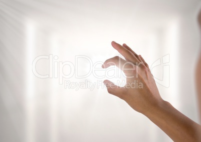 Hand interacting and pinching with bright light shining through fingers