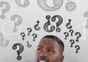 Man looking up at question marks