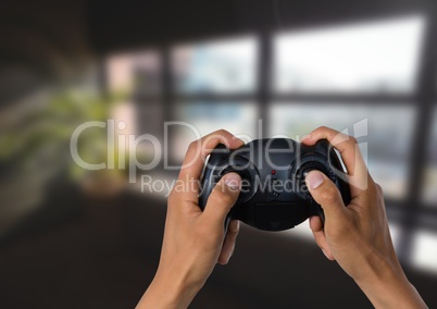 Hands playing with computer game controller with bright blurred background