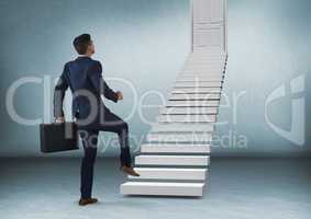 Businessman with briefcase walking up stairs to door