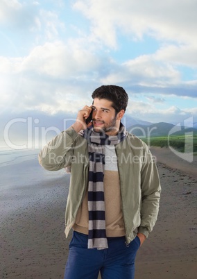 man on phone with scarf on beach