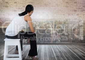 Businesswoman sitting on stool looking out over city
