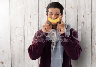 Man against wood with banana and scarf
