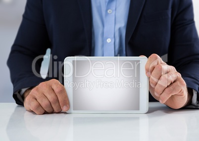 Businessman at desk with tablet with bright background