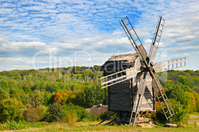 wooden windmill in field and sky