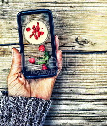 Healthy Eating. Smartphone in a female hand. display image of strawberry milkshake