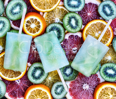 Concept: summer, heat, quenching thirst. Fruit ice, sliced fruit, kiwi, orange, grapefruit.